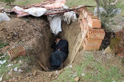 Ölmeden mezarını kazdı, geceleri içine girip yatıyor