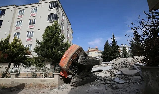 Hasarlı bina iş makinesi üzerine devrildi